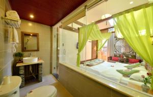 bagno con letto, lavandino e specchio di Lewo Guest House a Lijiang