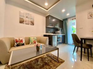 una sala de estar con un sofá y una mesa en Arcadia Continental 1 bedroom Pool View, en Pattaya South