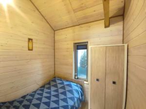 a small room with a bed and a window at Mazury Dom Oluś nad jeziorem Sasek Wielki z gorącą balią in Szczytno