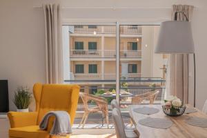 a living room with a table and a yellow chair at On the south coast of the island Ribeira Brava I in Ribeira Brava