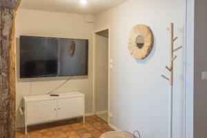 a living room with a flat screen tv on a wall at Coeur de Blois Maison T3 in Blois