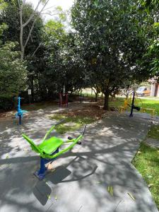 a park with a playground with a green bench at Casa com piscina em condomínio fechado in Águas de Lindóia