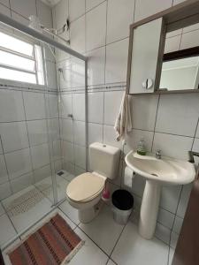 uma casa de banho branca com um WC e um lavatório em Casa com piscina em condomínio fechado em Águas de Lindoia