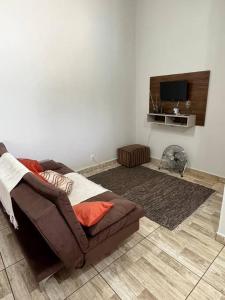 a living room with a couch and a flat screen tv at Casa com piscina em condomínio fechado in Águas de Lindoia