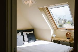 a bedroom with a bed and a window at Hoeve de Reetjens - La Gouvernante in Bilzen