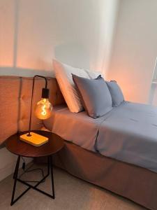 a bed with pillows and a lamp on a table at Appartamento Dolce Vita - Parking & Self Check-in in Como