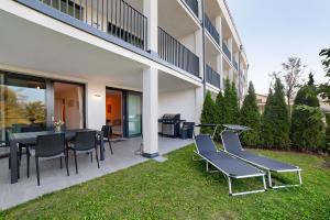 a patio with chairs and tables and a building at Apartement Panoramaresidence in Avelengo