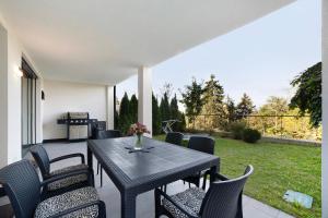 un patio con tavolo, sedie e griglia di Apartement Panoramaresidence a Avelengo