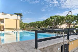 een zwembad met een zwarte leuning naast een gebouw bij Lydie apt. exclusive holigarda in Desenzano del Garda