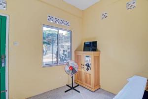 a room with a fan and a window at SPOT ON 92914 Meranti Homestay in Pekanbaru