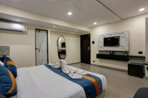 a bedroom with a large bed and a tv at DIAMOND HOTEL in Mumbai