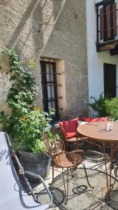 a patio with a table and chairs and a building at Cocooning in Arvier