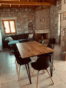 a wooden table and chairs in a room with a fireplace at Villa Pantazi in Riglia