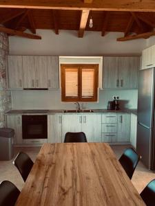 a kitchen with a wooden table and chairs in it at Villa Pantazi in Riglia
