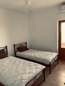 a bedroom with two beds and a window at Villa Pantazi in Riglia