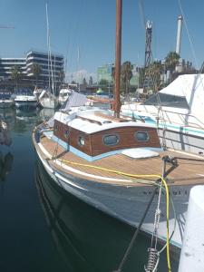 a sailboat docked in a harbor with other boats at Lovely wooden boat in Port forum, with AC and two bikes. in Barcelona