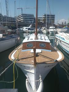 a boat is docked in a harbor with other boats at Lovely wooden boat in Port forum, with AC and two bikes. in Barcelona
