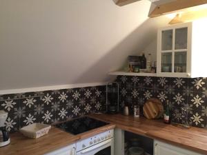 a kitchen with black and white tiles on the wall at Ferienhaus Kaept n Poldi 25192 in Bunde