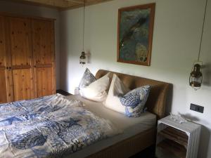 a bedroom with a bed with blue and white pillows at Ferienhaus Kaept n Poldi 25192 in Bunde