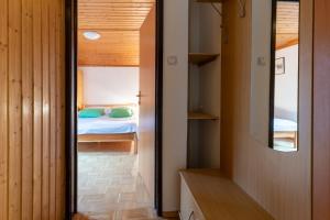 a small bedroom with a bed and a mirror at Apartments Pri Urhu in Bohinj