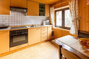 a kitchen with wooden cabinets and a table with a bowl of fruit at Apartments Pri Urhu in Bohinj