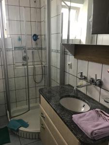 a bathroom with a sink and a shower with a shower at Ferienwohnung Roth in Memmingen