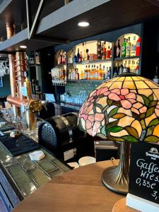 a bar with a stained glass umbrella sitting on a table at Lohmann's Kapeller Hof in Langenfeld