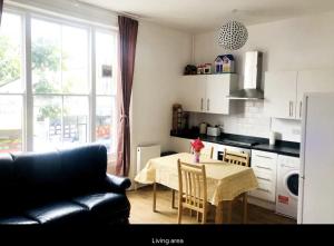 sala de estar con mesa y sofá negro en Lovely Flat in Central London, en Londres