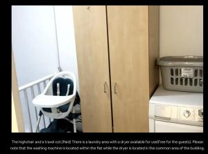 uma cozinha com uma cadeira e uma máquina de lavar roupa em Lovely Flat in Central London em Londres