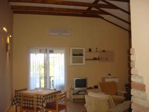 a living room with a table and a television at Apartments in Silo/Insel Krk 13442 in Šilo