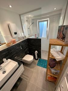 uma casa de banho com um lavatório, um WC e um espelho. em Seibels SUITES - Wohnung Ruhrgebiet em Herne