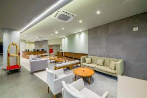 una sala de espera con sofás, mesas y sillas en Laghetto Resort Golden Oficial en Gramado