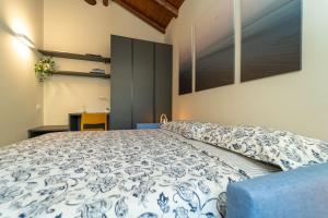 a bedroom with a bed with a blue and white comforter at Moderno Appartamento a 200 metri dal Duomo in Como