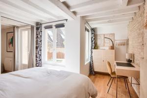 een witte slaapkamer met een bed en een bureau bij Le Matilda - Appt Hypercentre 2 pers in Caen