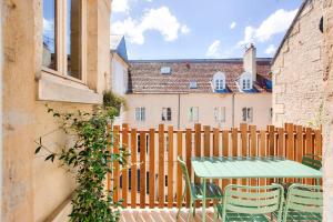 a wooden fence with a table and chairs on a patio at Le Matilda - Appt Hypercentre 2 pers in Caen