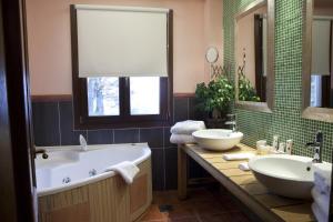 a bathroom with two sinks and a mirror at Kazarma Hotel in Kalyvia Fylaktis