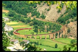 un tren viajando por una pista en una montaña en Al Piazzo 414, en Brusio