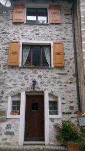 a stone building with a door and two windows at Al Piazzo 414 in Brusio