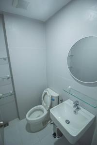 uma casa de banho com um WC, um lavatório e um espelho. em Twin Hearts Residences 1 em Roxas City