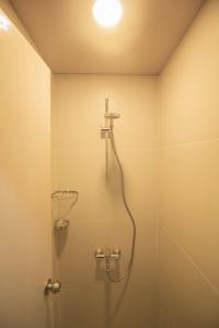 uma casa de banho com chuveiro e cabeça de chuveiro em Twin Hearts Residences 1 em Roxas City
