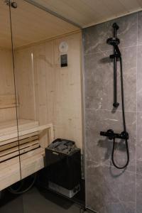 um chuveiro num quarto com uma parede de vidro em Hotel OmaBox - Nivala - Oma huoneisto saunalla em Nivala