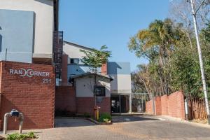 a brick building with a red corner sign on it at Rand Corner Crib in Pretoria