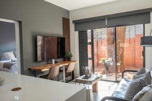 a living room with a table and a large window at Rand Corner Crib in Pretoria
