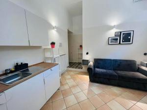 Una cocina y una sala de estar con un sofá. en Eccelso Suites, en Roma