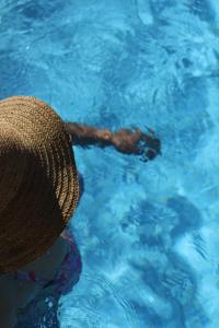 a person wearing a straw hat in a swimming pool at Casa da Aldeia da Avó in Valpaços