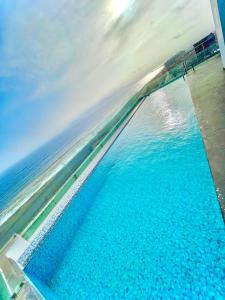 ein Pool mit blauem Wasser am Meer in der Unterkunft Departamento Nuevo con piscina frente al mar in Lima