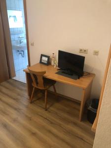 a wooden desk with a computer on top of it at Brauereigasthof Hotel Schlüssel in Giengen an der Brenz