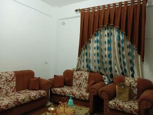 a living room with two brown couches and a table at Flowers apartment in Amman