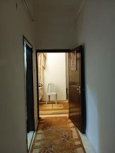 a hallway with a door and a chair in a room at Flowers apartment in Amman