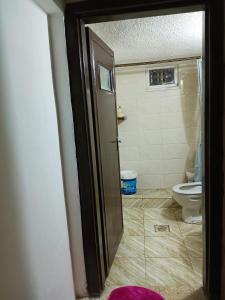 an open door to a bathroom with a toilet at Flowers apartment in Amman